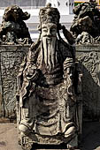 Bangkok Wat Arun - Detail of the precint of the sacred area of the ubosot with chinese noble man sitting on chair. 